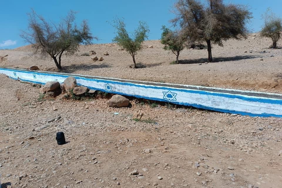 Des colons dessinent le drapeau de l'État occupant sur le cours de la source Al-Auja, au nord de Jéricho.